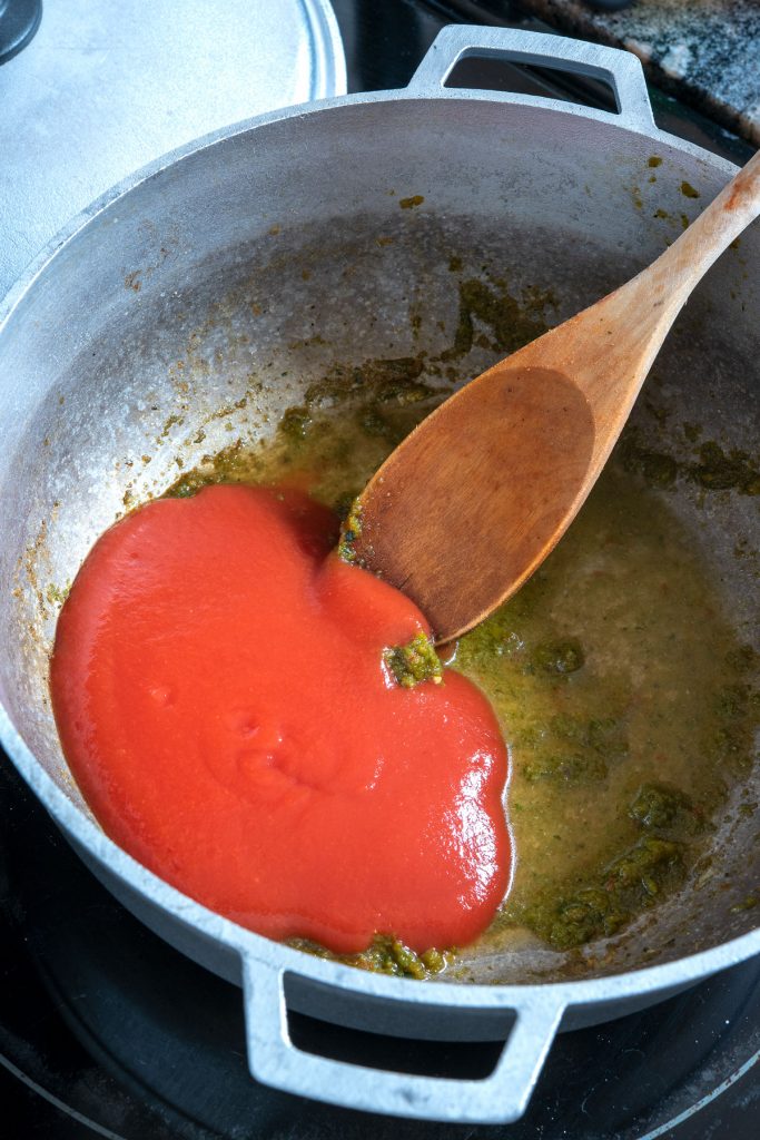 Cooking tomato sauce for chuletas guisadas