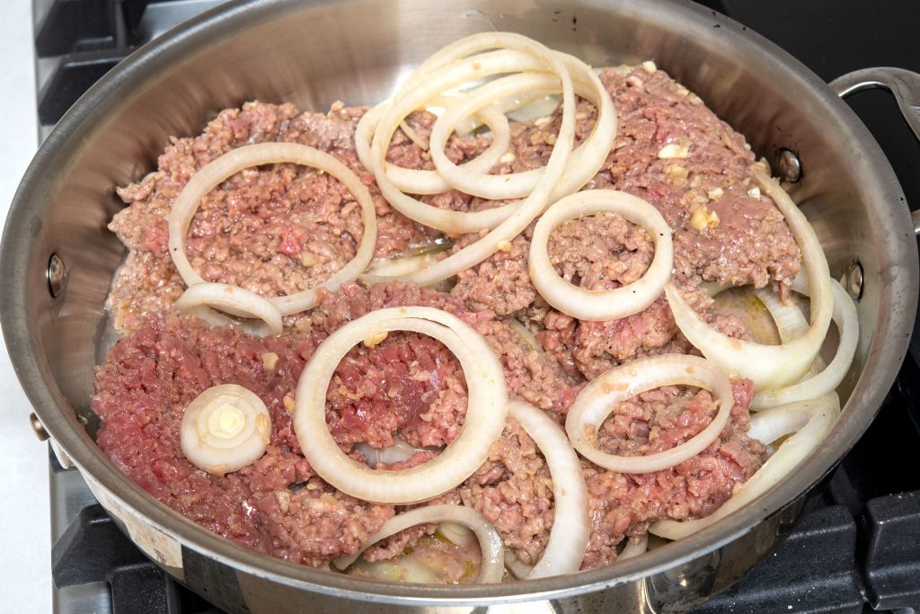 Steak and onions cooking in skillet