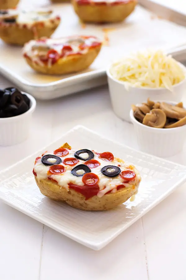Change up pizza night by using baked potatoes as the crust! Add sauce, cheese and your favorite toppings to these pizza baked potatoes! | Kitchen Gidget
