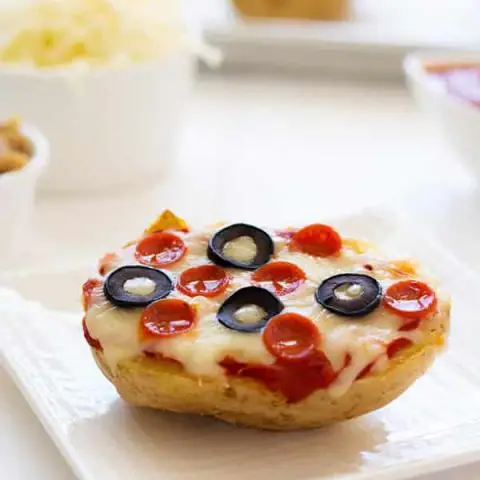 Change up pizza night by using baked potatoes as the crust! Add sauce, cheese and your favorite toppings to these pizza baked potatoes! | Kitchen Gidget