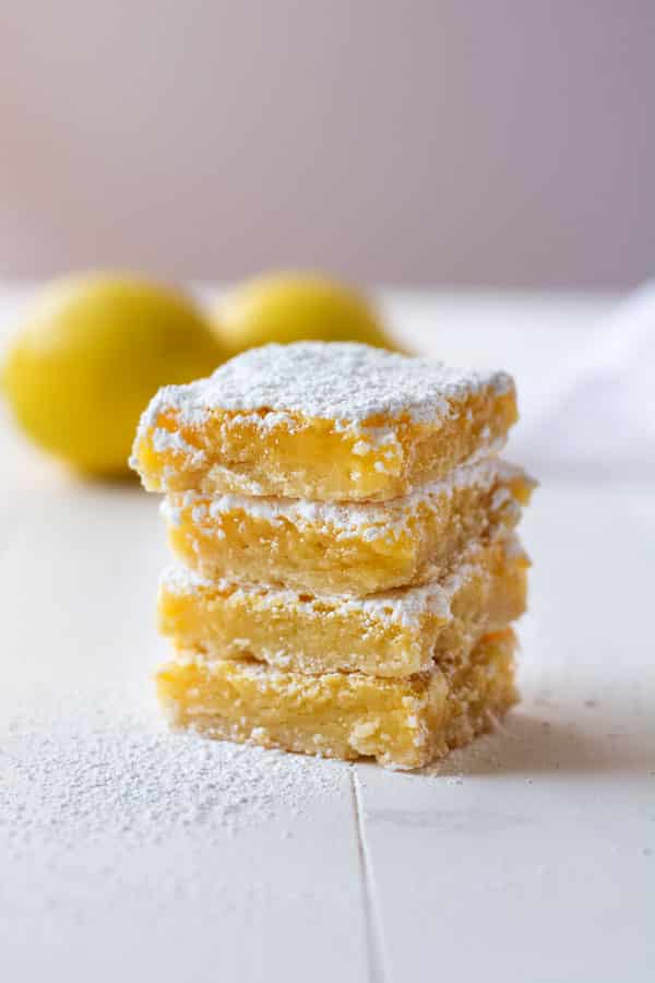 Sweet and tart homemade lemon squares with a shortbread crust! Light and crisp cookie base topped with ooey gooey lemon filling!