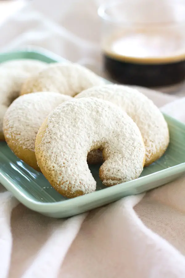 Almond Crescents made with ground almonds, flavored with vanilla and dusted with powdered sugar. These buttery crescents are crisp on the outside and tender on the inside. They’re perfect snowy cookies for the holidays!