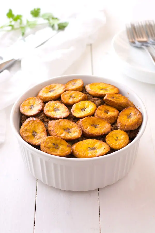 Piñon is a hearty plantain casserole made with layers of picadillo, fried ripe plantains, kidney beans and green beans. Try this Puerto Rican beef and plantain piñon recipe today!
