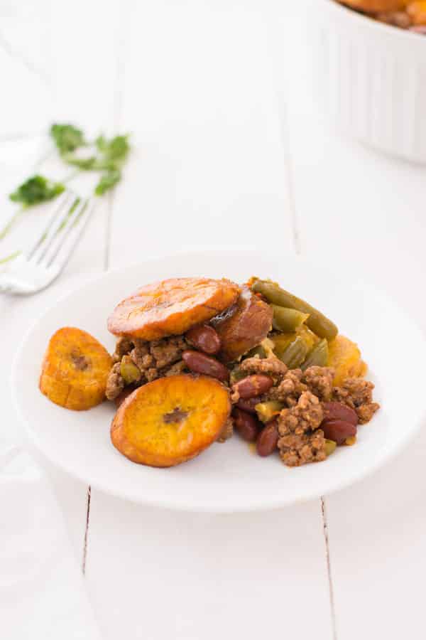 Piñon is a hearty plantain casserole made with layers of picadillo, fried ripe plantains, kidney beans and green beans. Try this Puerto Rican beef and plantain piñon recipe today!