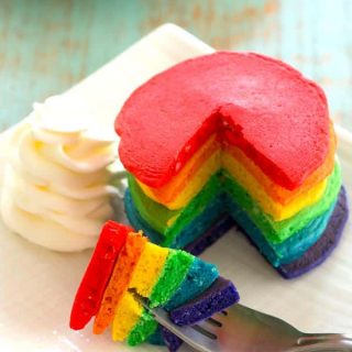 Serve these rainbow pancakes for St. Patrick's Day breakfast! Colored pancakes with fluffy "clouds" of whipped cream are lucky indeed!