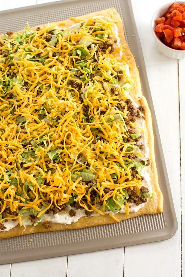 Taco Pizza Appetizer with a crescent roll crust. Easy cream cheese sauce is so zesty!