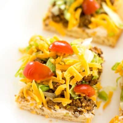 Taco Pizza Appetizer with a crescent roll crust. Easy cream cheese sauce is so zesty!
