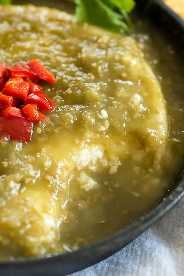 Baked Queso Fresco Dip in green salsa verde. Serve this appetizer in a cast iron skillet with chips!
