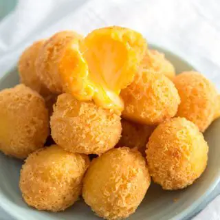 Hot bolitas de queso (deep fried cheese balls) with melted, gooey cheese. Easiest appetizer ever!