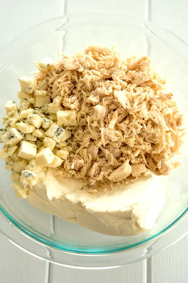 How to make buffalo chicken dip: start with shredded chicken, blue and cream cheeses