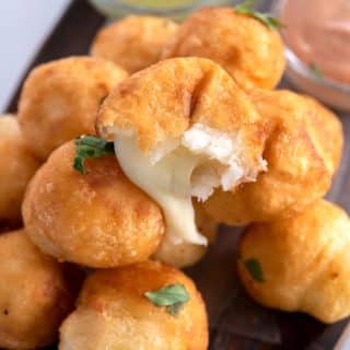 Platter of Bolitas de Yuca with melted cheese oozing out