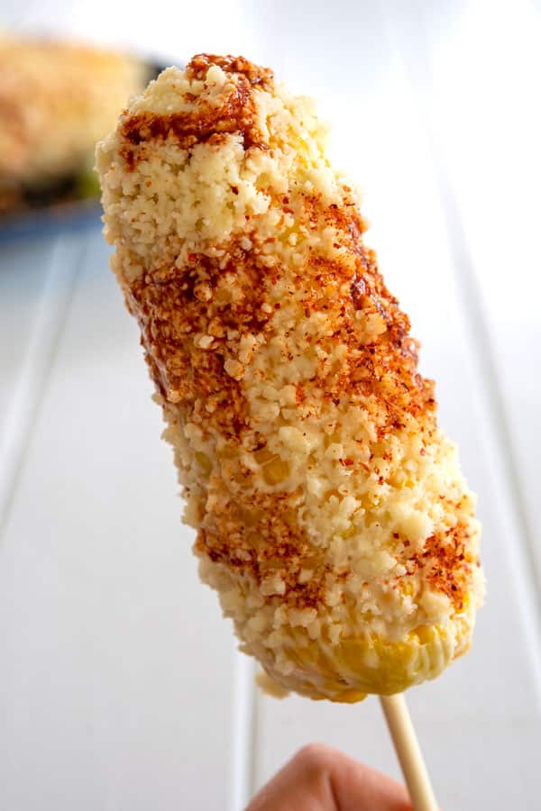 One elote (Mexican corn on the cob) with mayo, cheese, chile and lime