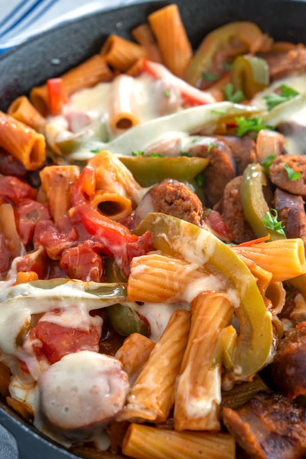Sausage and peppers pasta topped with melted cheese