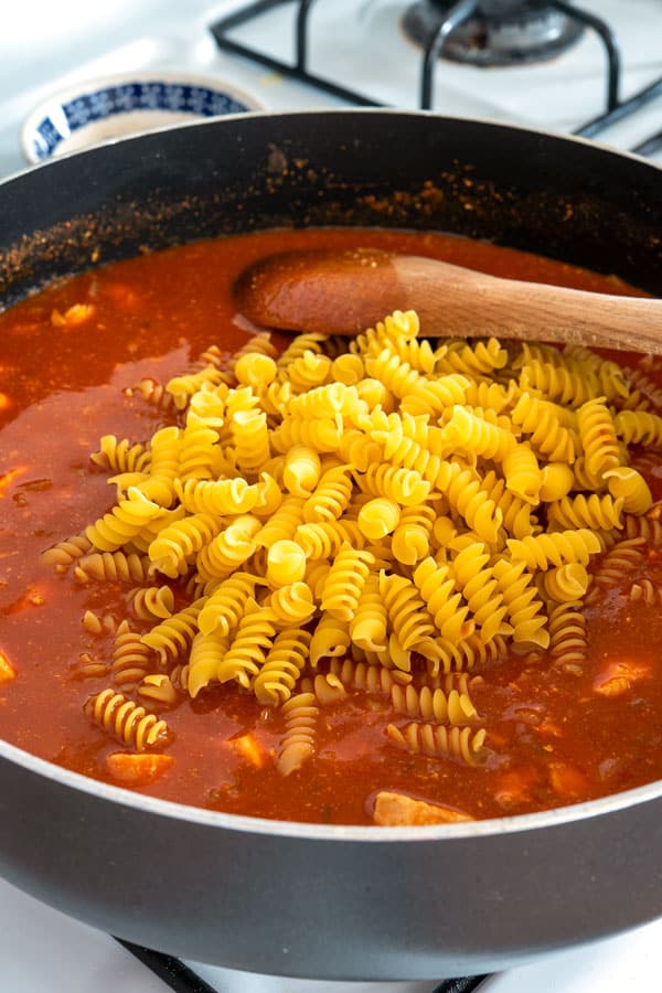Pasta and sauce in pan for chicken enchilada pasta