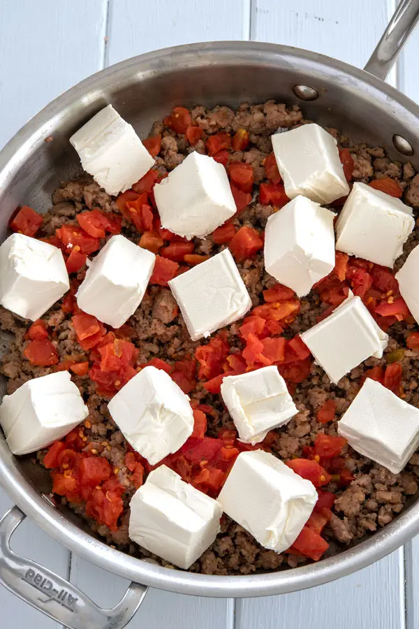 Sausage, Rotel and cream cheese cooking in skillet for sausage cream cheese dip