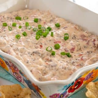 Sausage cream cheese dip in serving dish garnished with green onions