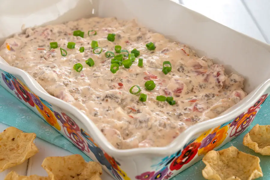 Sausage cream cheese dip in serving dish garnished with green onions