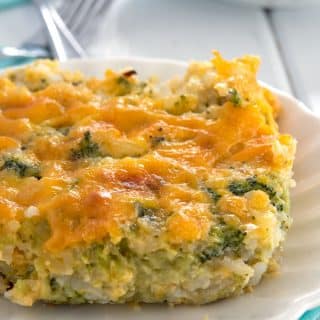 One serving of broccoli cheese rice casserole on small white plate