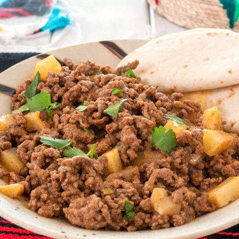 Plate of picadillo with flour tortillas on side