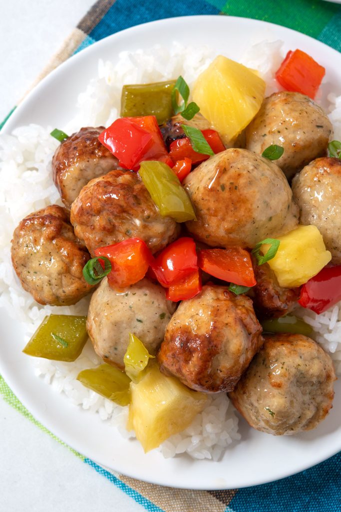 Overhead view of sweet and sour meatballs with rice on a plate