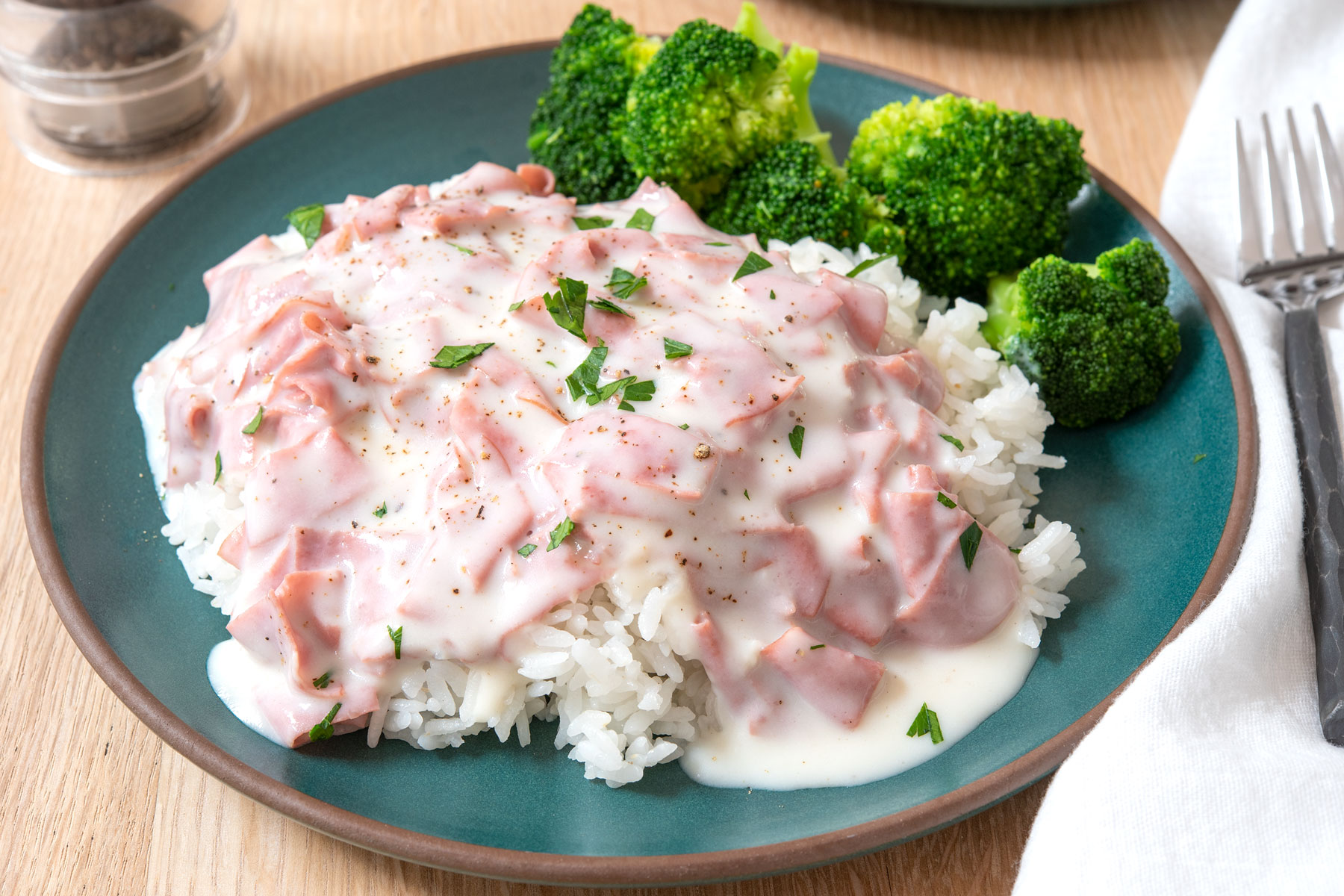 Plate of chipped beef over rice with steamed broccoli.